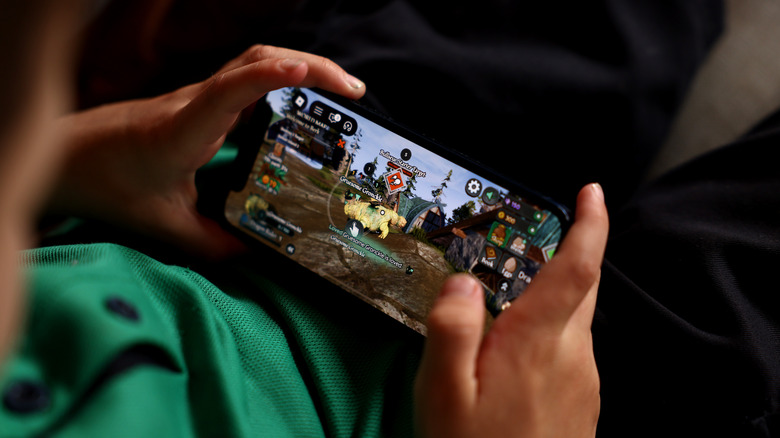 A child playing a mobile game on a smartphone