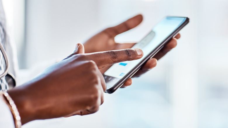 a person's hands touching the screen on their phone