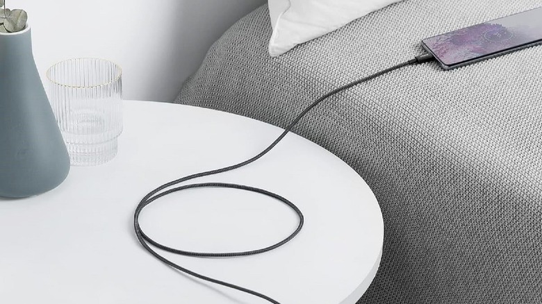 Anker USB C cable plugged into a phone on the bed.