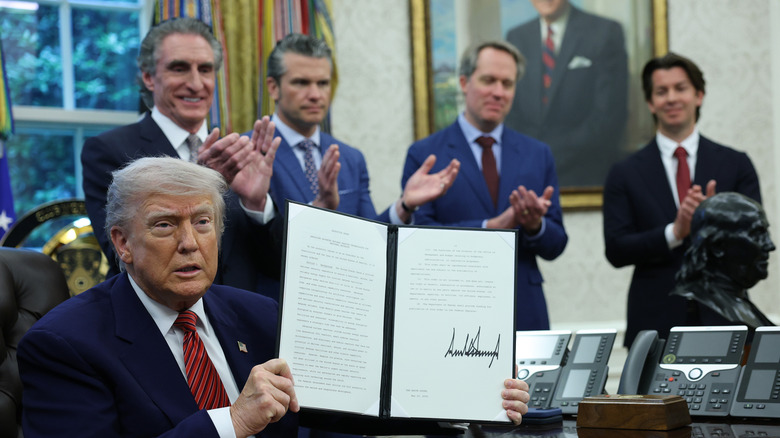 Nuclear energy developers and U.S. Defense Secretary Pete Hegseth clap as President Trump displays his Executive Order to fast track U.S. Nuclear Energy.