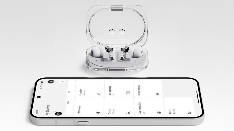Nothing Ear (3a) earbuds in a case in front of a phone with the Nothing X app open