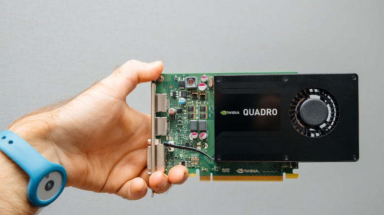 A person holding NVIDIA Quadro graphics card.