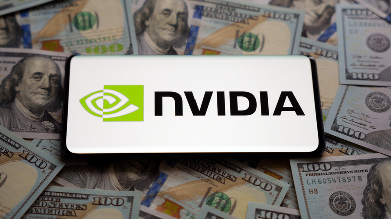 The Nvidia logo displayed on a smartphone atop a pile of cash