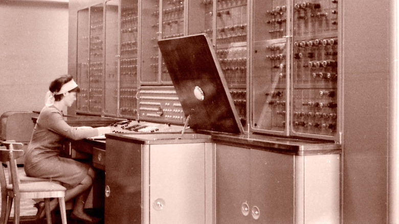 A woman seated while working on a vacuum tube-based computer in the 1960s.