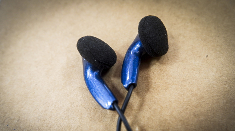 A pair of wired earbuds laid on a flat surface.