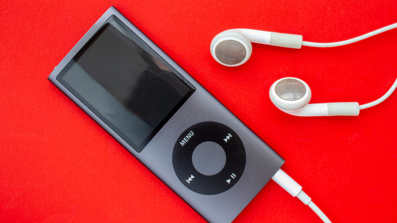 An iPod Nano with headphones on red background