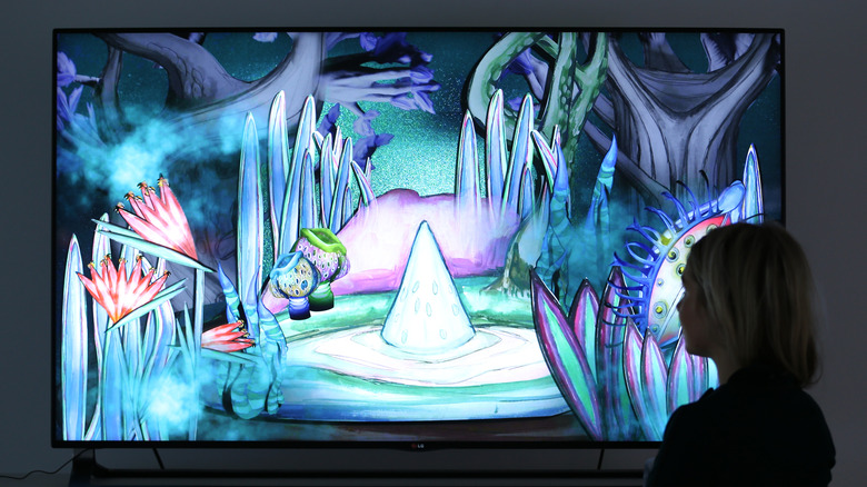 A woman looking at artwork on an OLED TV
