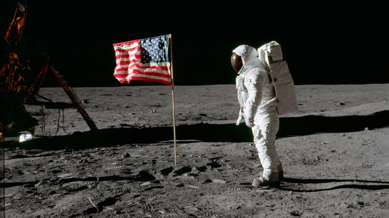 Buzz Aldrin beside an American flag on the Moon.