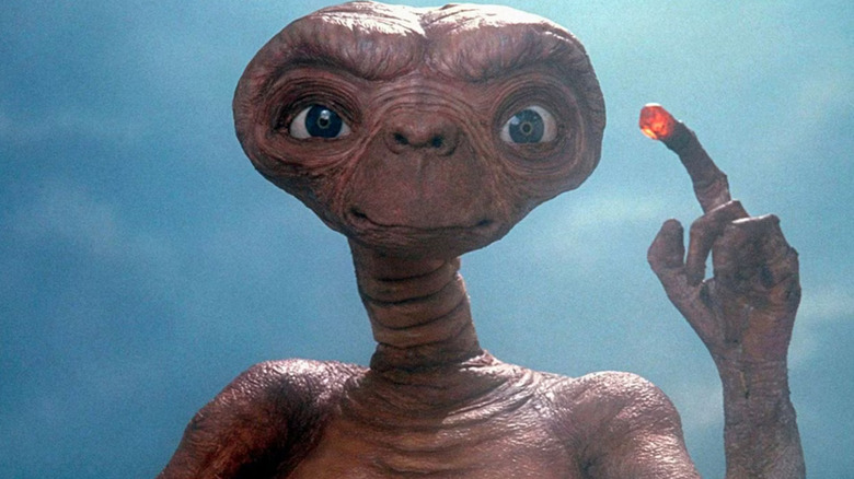 E.T. slightly smiling and holding his finger up