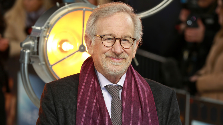Steven Spielberg wearing a suit and scarf.