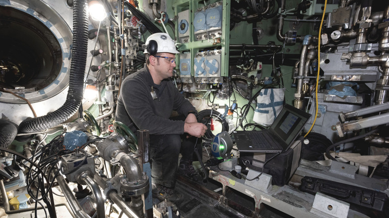 A worker uses a laptop at the SSN-798 nuclear submarine's production facility.
