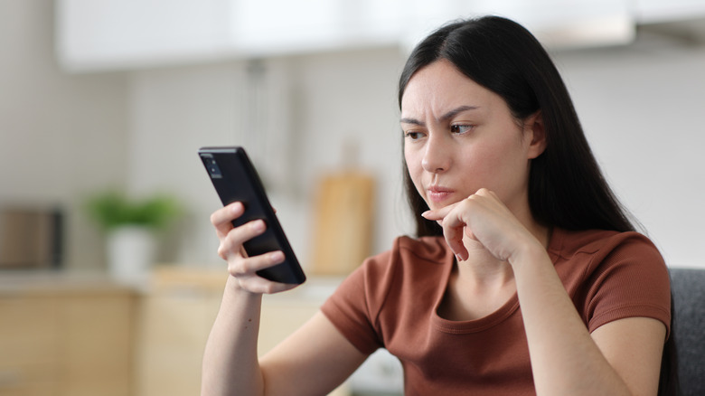 A woman reading a message on her phone