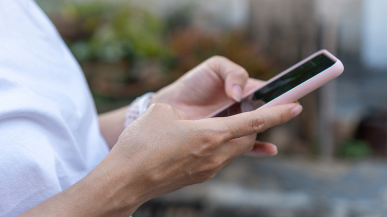 a person holding a generic smartphone while interacting with it