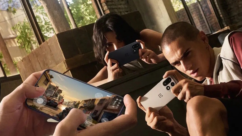 Multiple people playing games on a OnePlus 15 in a room