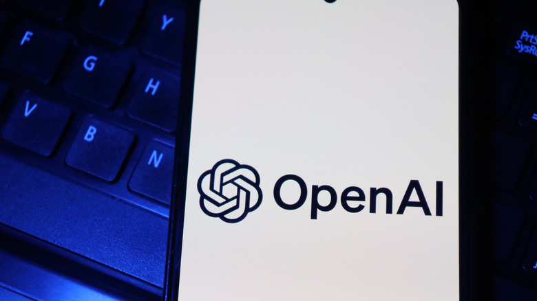 OpenAI logo on a smartphone sitting on top of a keyboard