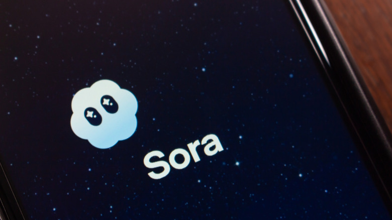 close-up of sora app icon and loading screen on smartphone, desk or table visible in background