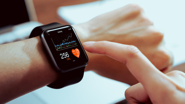 Close up of a person wearing a Apple Watch on their wrist which is measuring their health metrics including heart rate