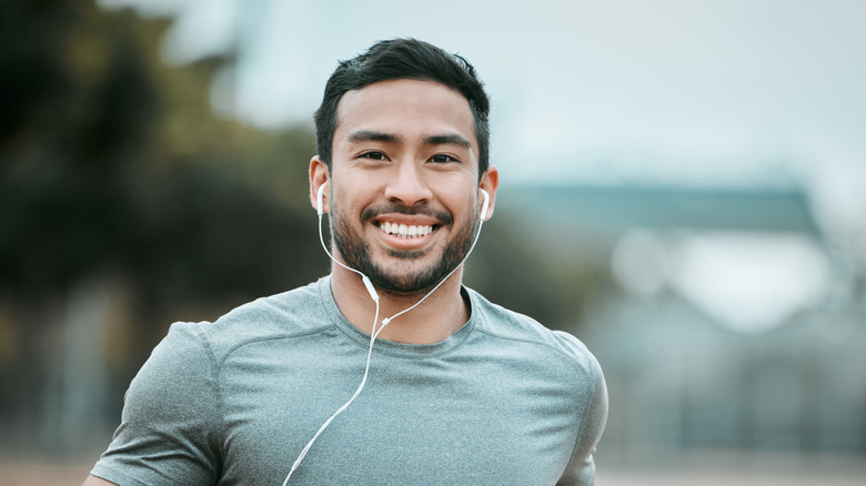 A person exercising while wearing in-ear headphones