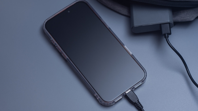 Smarphone next to a charger.