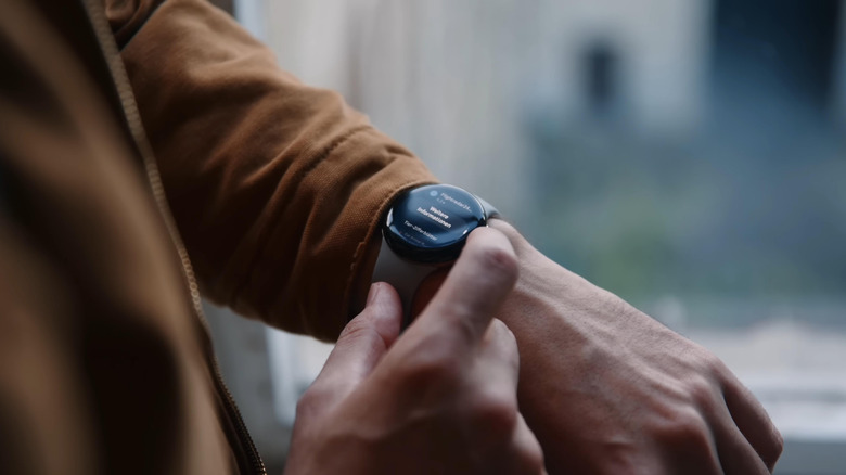A person interacting with the Pixel Watch 2 worn on their wrist