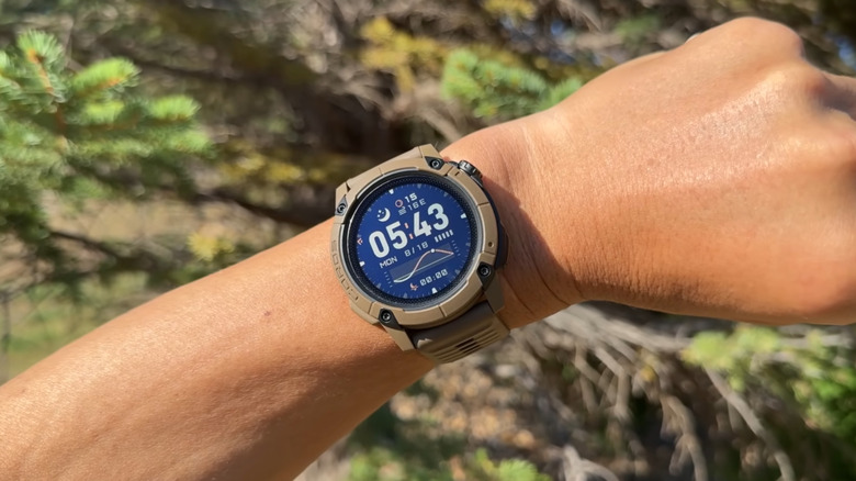 A COROS smartwatch on a person's wrist showing the time.