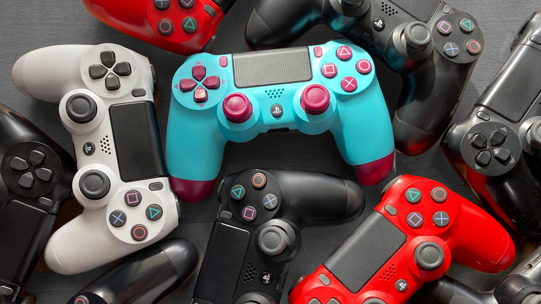 Pile of PlayStation 4 DualShock 4 controllers in multiple colors