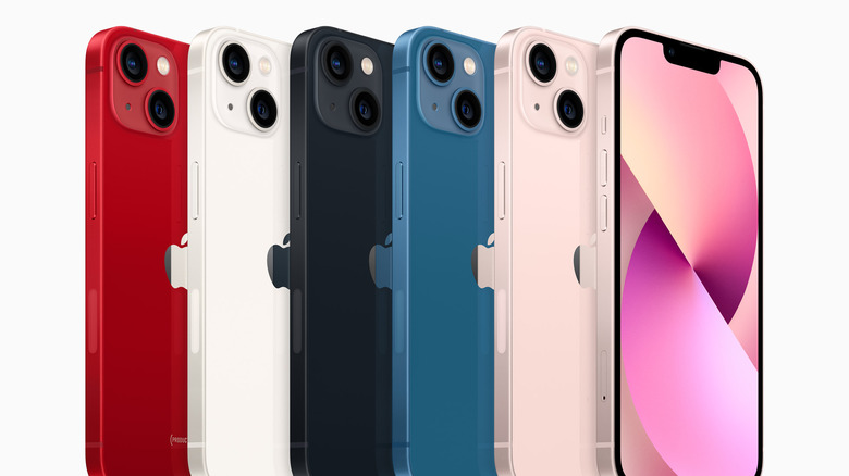 A row of iPhone 13s in different colors
