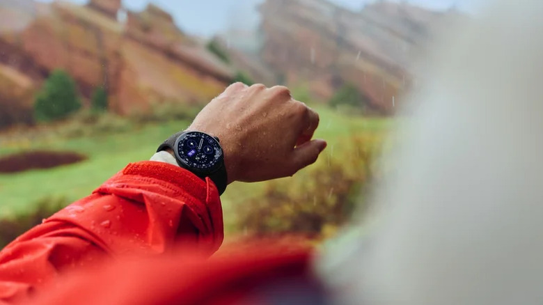 person in red jacket with Pixel Watch 4 on wrist.