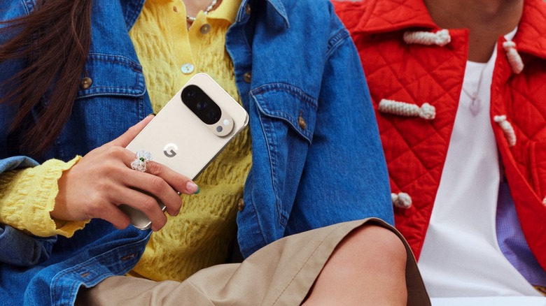 woman holding Google Pixel 10 Pro in Porcelain.