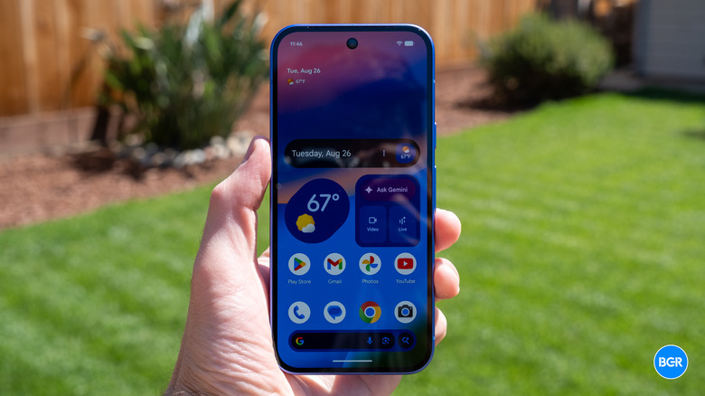 The Pixel 10 in hand with the display turned on.