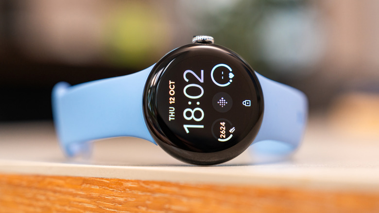 a pixel watch 2 on its side on a wooden surface