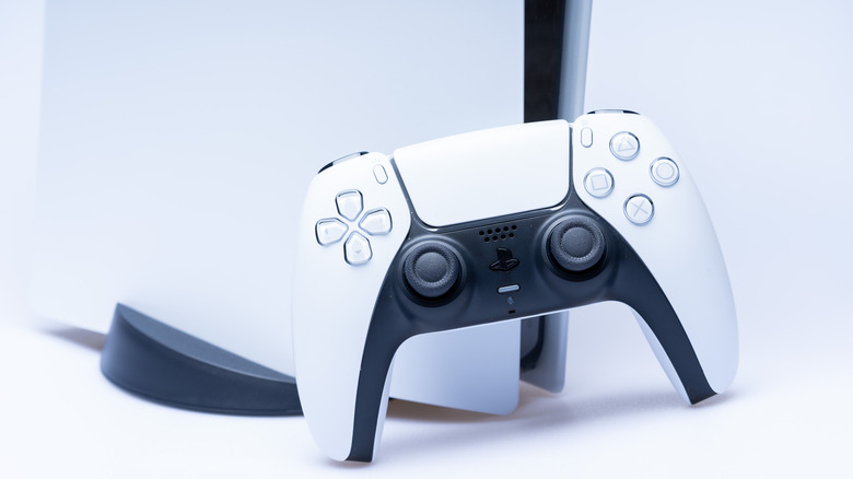 A PS5 console with a controller in the foreground.