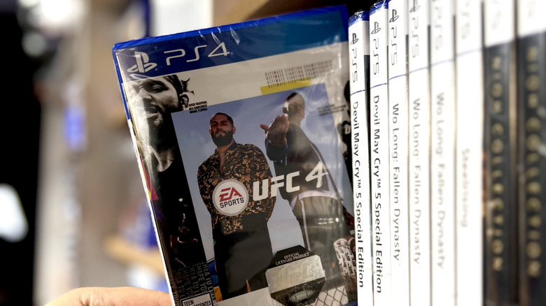 A physical PS game being pulled from a shelf.