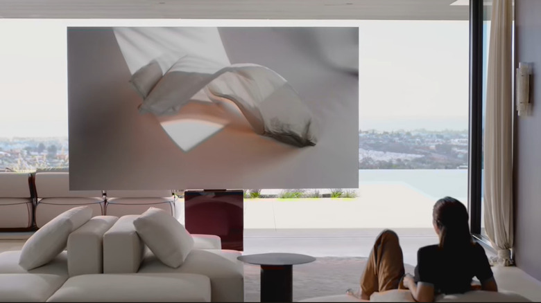 a person watching the C Seed N1 TV on a sofa.