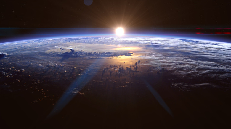 sunlight breaking across planet Earth in space