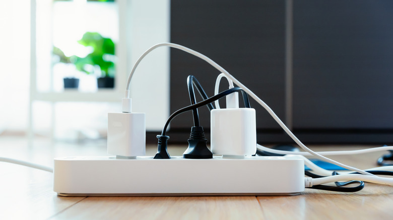Power strip with multiple power adapters and cords plugged in.
