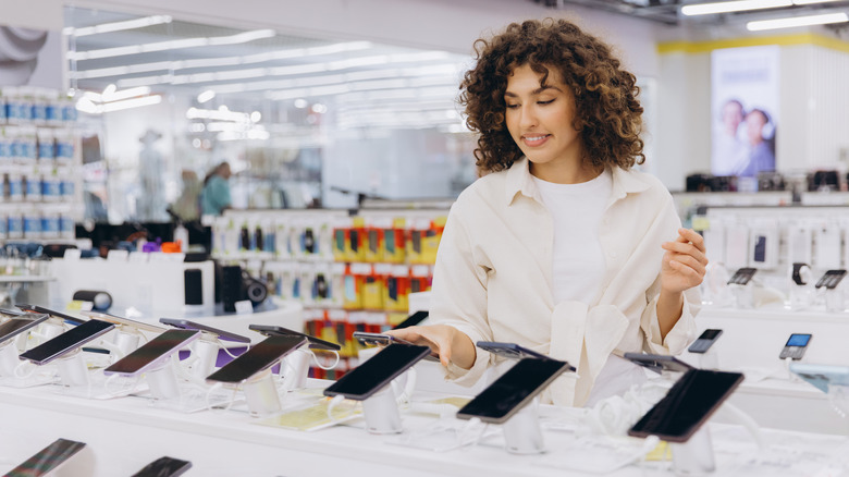 A person looking through smartphones for sale at an electronics store