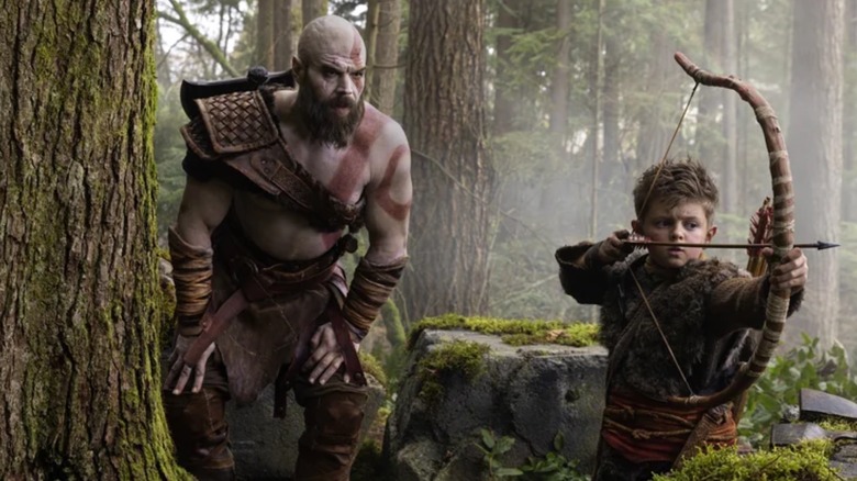 Ryan Hurst as Kratos watching Callum Vinson as Atreus firing a bow