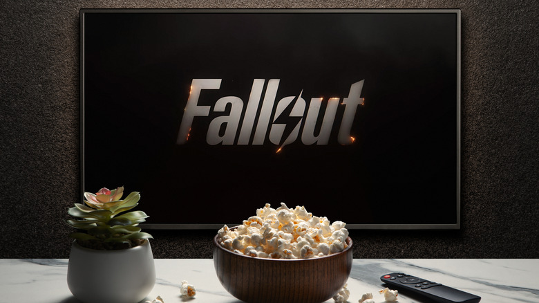 Fallout series logo on TV with popcorn and remote in foreground