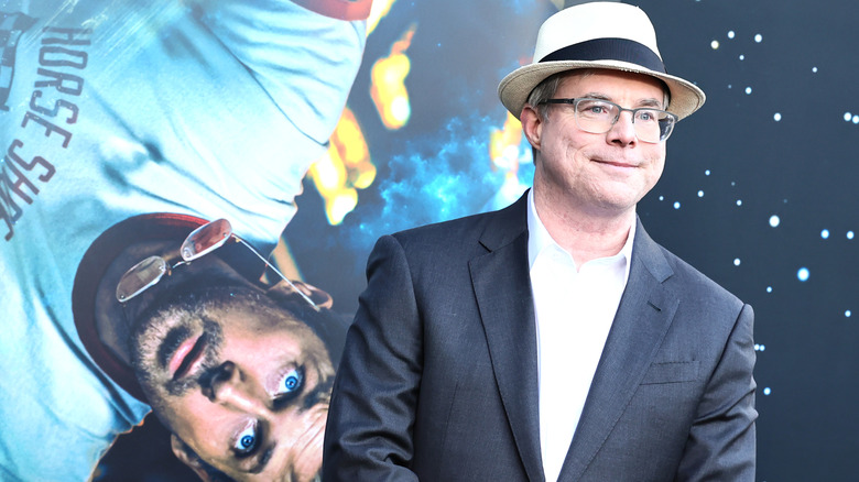 Author Andy Weir at the Project Hail Mary premiere standing in front of a picture of Ryan Gosling as Ryland Grace.