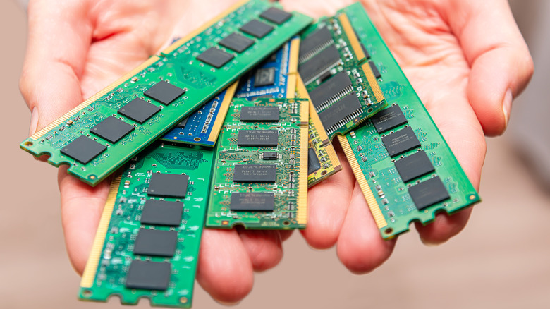 Closeup of two hands holding a number of RAM chips