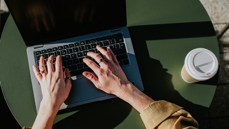 Top-down view of a man typing on a laptop
