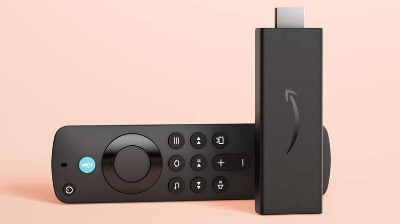 Amazon Fire Stick HD standing up with remote behind on a pastel background