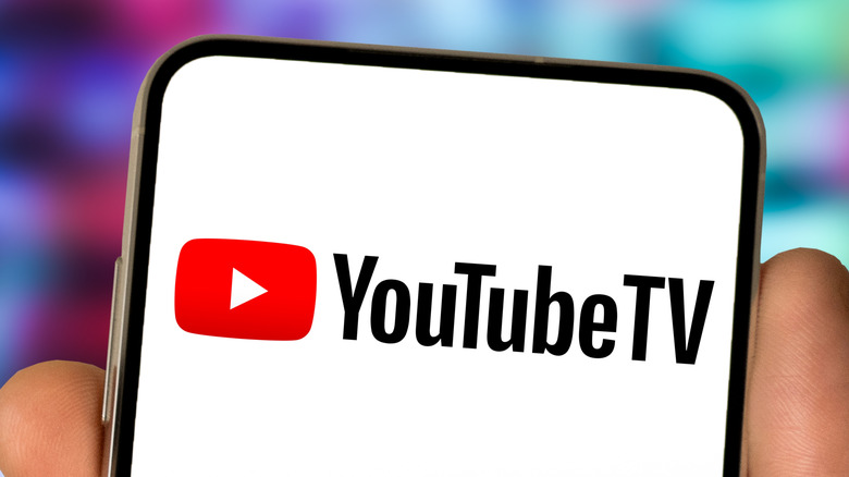 Person holding a phone with the YouTube TV logo