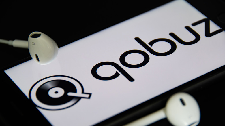 The Qobuz logo displayed on a smartphone lying on a table