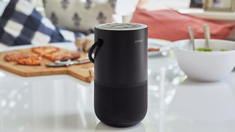 The Bose Portable Home smart speaker on a table with some food.