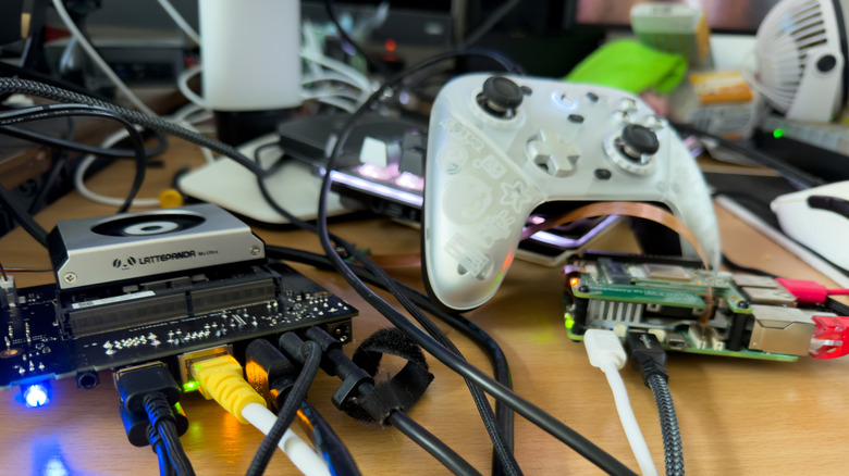 A messy desk with a controller, Mu Ultra and Pi 5