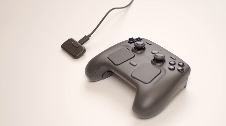 Steam Controller next to it's charging puck.