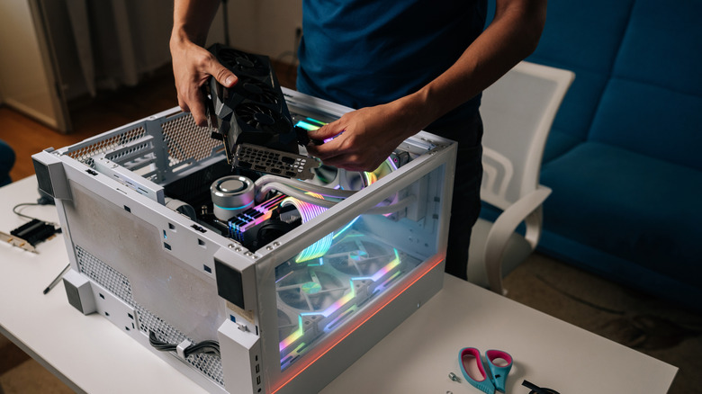 Someone inserting a graphics card in a high-end looking desktop