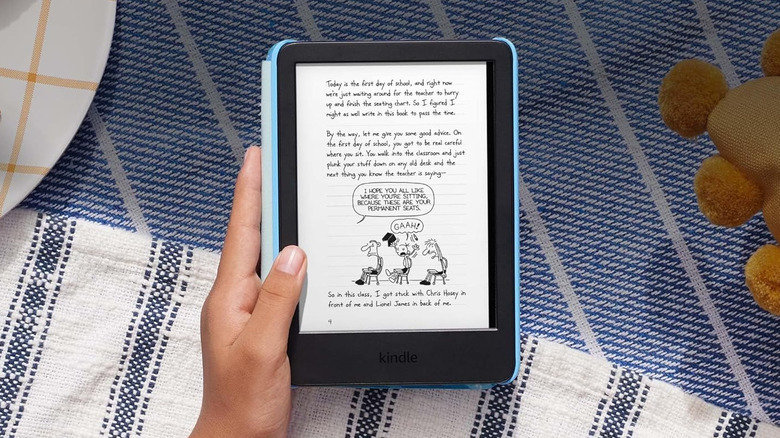 Hand holding Kindle Kids e-reader displaying illustrated ebook page